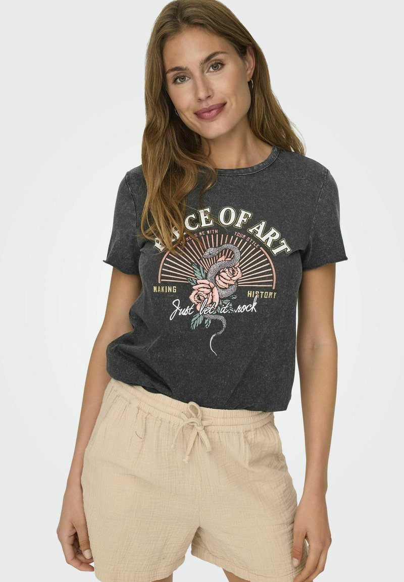Grijs katoenen T-shirt met een grafisch ontwerp van rozen, tekst en stralen. Combinatie met beige textuuroveralls, geschikt voor casual draag.