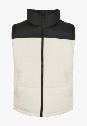 Pufjackets ar augstu apkakli, ar melnu augšējo daļu un krēmīgu apakšu, priekšējais rāvējslēdzis un divas sānu kabatas. Strukturēta auduma.