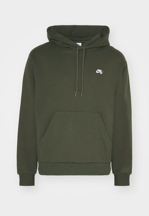 Haut à capuche vert olive avec une poche kangourou à l'avant, des cordons de serrage et un logo Nike blanc sur la poitrine. Fabriqué en tissu doux et texturé.
