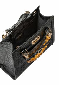 Zwarte handtas van krokodillenleder met een gestructureerd ontwerp, gouden hardware en een bamboe handvat. Het interieur is ruim en gestructureerd.