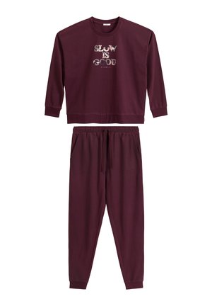Burgundowy bawełniany sweatshirt z nadrukiem "SLOW IS GOOD", w połączeniu z dopasowanymi spodniami dresowymi ze ściągaczem w pasie i kieszeniami.