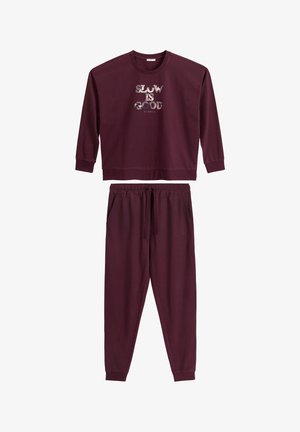 Burgundowy bawełniany sweatshirt z nadrukiem "SLOW IS GOOD", w połączeniu z dopasowanymi spodniami dresowymi ze ściągaczem w pasie i kieszeniami.