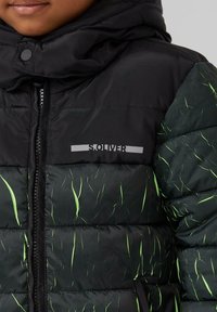 Giubbotto puffa nero con motivi a strisce verdi, chiusura con zip e cappuccio. Caratterizzato da un logo sul petto. Tessuto testurizzato con sezioni trapuntate.