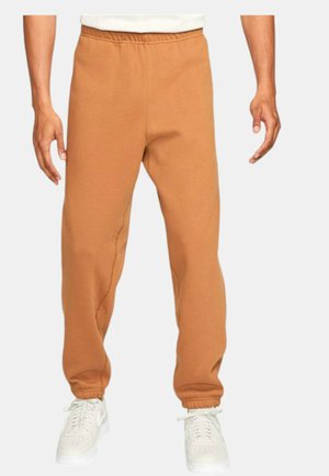 Sweatpants in a medium brown color, made of soft material. Features an elastic waistband and cuffed ankles for a tapered fit.