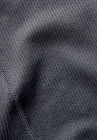 Tessuto a righe di un grigio scuro, con sottili linee verticali, caratterizzato da una texture delicata e cuciture visibili lungo il bordo.