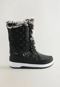 Czarne wodoodporne zimowe buty z pikowanym wierzchem, futrzanym wykończeniem na górze, sznurowanym przodem i białą gumową podeszwą.