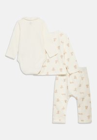 Σετ βρεφικών ρούχων σε κρεμ απόχρωση με κορμάκι μακρυμάνικο, μακρυμάνικο μπλουζάκι με εκτύπωση αρκουδάκι και παντελόνι που ταιριάζει.
