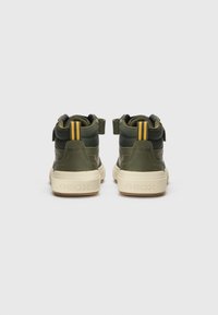 Ciemnozielone sneakersy za kostkę z kontrastującymi żółtymi paskami, teksturowana tkanina, rzep i beżowa gumowa podeszwa. Logo GEOX na obcasie.