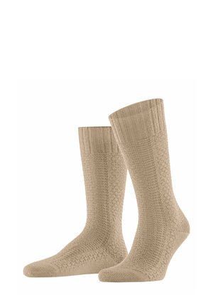 Beige cotton socks with a textured, ribbed design and a honeycomb pattern on the shaft, featuring a reinforced heel and toe.