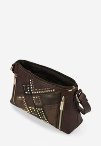 Bolso de piel marrón con tachuelas en tono dorado, paneles texturizados y cierre con cremallera. Cuenta con una correa para el hombro y múltiples compartimentos.