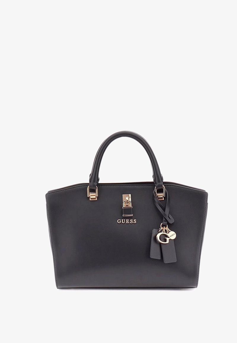 Bolso de mano de cuero negro con diseño estructurado, doble asa, herrajes dorados y logotipo "GUESS" en relieve; incluye un charm decorativo con etiquetas.