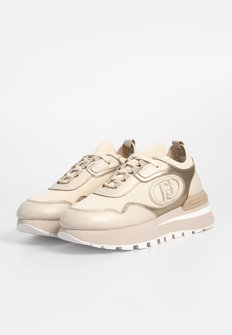 Scarpe sportive beige con pelle liscia e tessuto testurizzato, dotate di suola spessa, punta rotonda e dettaglio del logo sul lato.