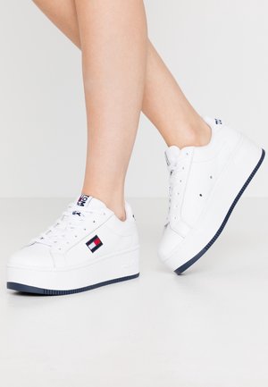 Hvide platform-sneakers lavet af læder med en tekstureret sål. Har en logo-patch i rød, hvid og blå på siden og snørebånd.