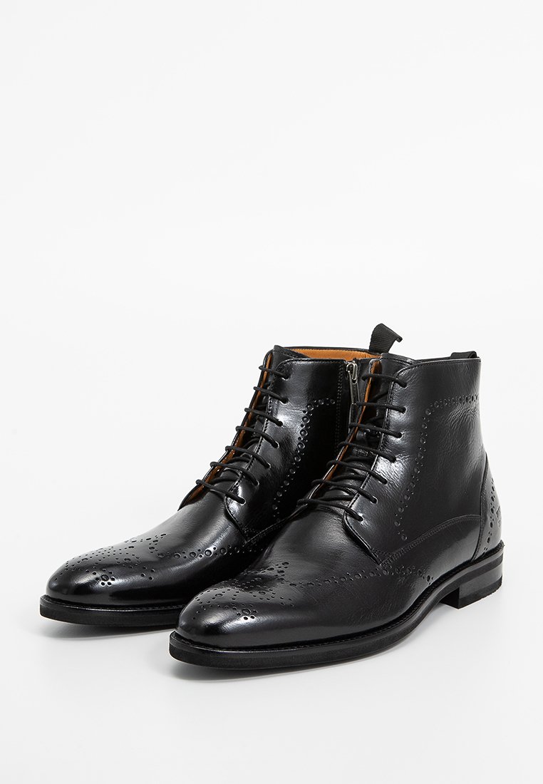 Schwarze Lederstiefeletten mit glatter Oberfläche, spitz zulaufender Zehenpartie, detaillierten Perforationen und Schnürung an der Vorderseite. Holzohr mit minimalen Akzenten.