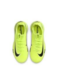 Zapatos de fútbol en un vibrante color amarillo neón con un diseño elegante. Presenta el característico swoosh negro de Nike, una superficie texturizada y un sistema de cordones tradicional.