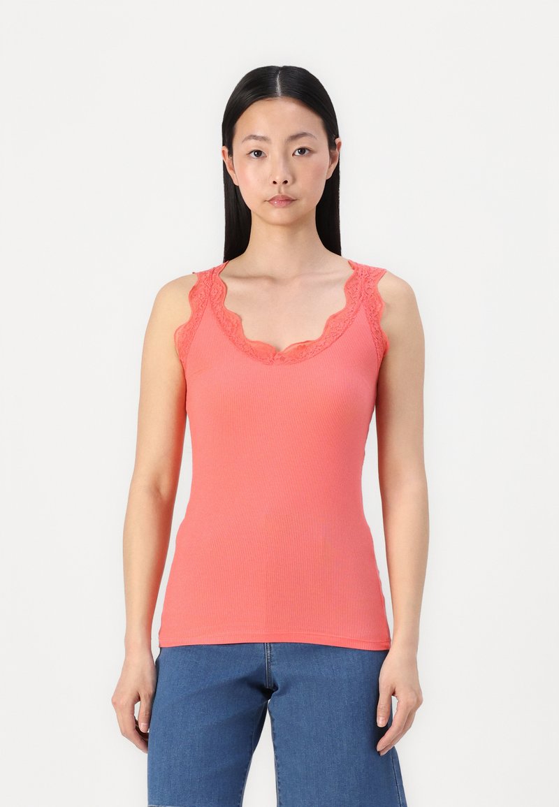 Top de tirantes acanalado en color coral con un borde de encaje ondulado a lo largo del escote y las correas de los hombros, con un diseño ajustado y textura suave.