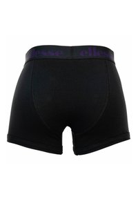Boxers noirs avec le logo ellesse violet sur la ceinture, montrés de dos sur un fond blanc.