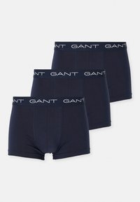 Drei dunkelblaue Herrenboxershorts mit schwarzen elastischen Bundbändern und weißen "GANT"-Logos, auf weißem Hintergrund dargestellt.