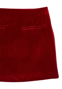 Gonna mini in velluto rosso con una texture liscia, caratterizzata da due tasche frontali e un design aderente. Il tessuto ha una leggera lucentezza.