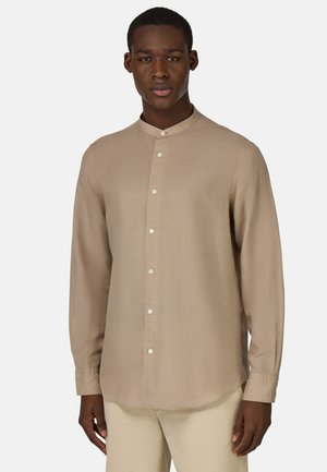 Camicia beige a maniche lunghe con colletto alla cinese, apertura frontale con bottoni e texture del tessuto liscia. Vestibilità su misura con orlo curvo.