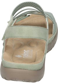 Ljusgröna sandaler med mjukt mockauppdrag, vadderad sula och flexibel gummisula. Har flera justerbara remmar för anpassning.