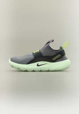 Γκρι αθλητικό παπούτσι slip-on με ανοιχτοπράσινη σόλα, μαύρο λογότυπο Nike, νεον πράσινη θηλιά τράβηγμα και κείμενο «Just Do It» στο πλευρικό λουράκι.