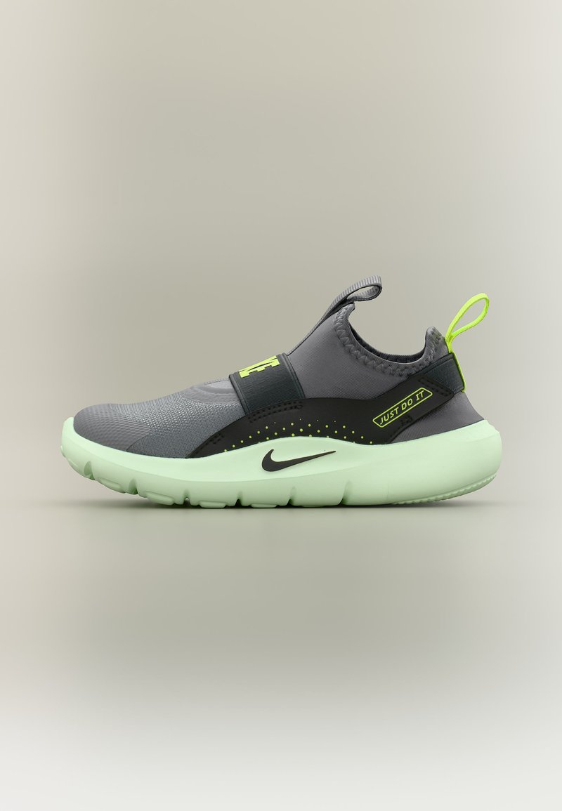 Γκρι αθλητικό παπούτσι slip-on με ανοιχτοπράσινη σόλα, μαύρο λογότυπο Nike, νεον πράσινη θηλιά τράβηγμα και κείμενο «Just Do It» στο πλευρικό λουράκι.