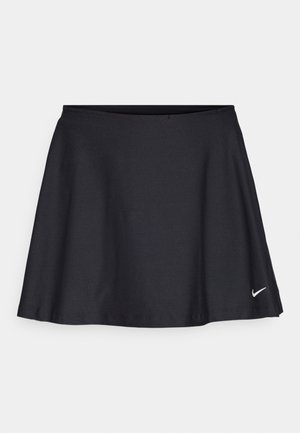 Svart sportkjol gjord av ett smidigt, flexibelt tyg. Utrustad med en vid form och elastisk midja; har en liten vit Nike-logotyp vid fållen.