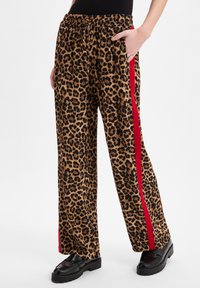 Leopardprint wijde broek met een zwarte tailleband en rode zijstrepen, voorzien van een elastische trekkoord en zijzakken.