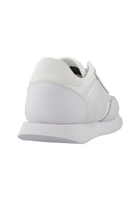 Scarpa sportiva bianca con esterno in pelle liscia, forma arrotondata e suola ammortizzata. Presenta un branding minimale e un design elegante.