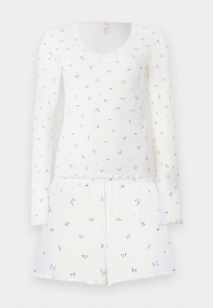 Wit geribd lange mouwen top en short set met kleine blauwe bloemenprint en gegolfde randen aan de manchetten, zoom en halslijn.