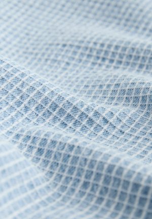 Tessuto testurizzato di colore azzurro chiaro con un motivo a griglia impreziosito da fili bianchi, che mette in risalto una finitura morbida e tessuta con un aspetto leggermente stropicciato.