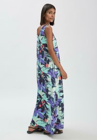 Maxikleid aus leichtem, fließendem Stoff mit floralen Mustern in Grüntönen, Purpur und Rot; ärmelloses Design mit lockerer Passform.