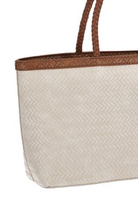 Bolso tote de paja tejido en color crema con un patrón espiga; presenta asas de cuero trenzado marrón y un borde texturizado para mayor durabilidad.
