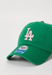 Grønn baseballcaps laget av bomull med en rosa brodert "LA"-logo på fronten, med buet skjerm og justerbar stropp.