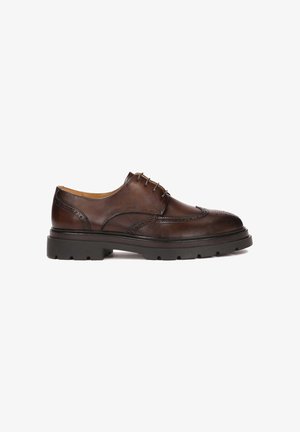 Chaussure habillée en cuir marron avec des détails en brogue, bout arrondi et semelle en caoutchouc marron. Dispose de cinq œillets et d'une finition lisse.