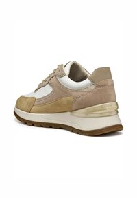Baskets beiges et blanches en matériaux suédé et cuir, dotées d'une semelle rembourrée, d'accents texturés et d'un logo transparent sur le talon.