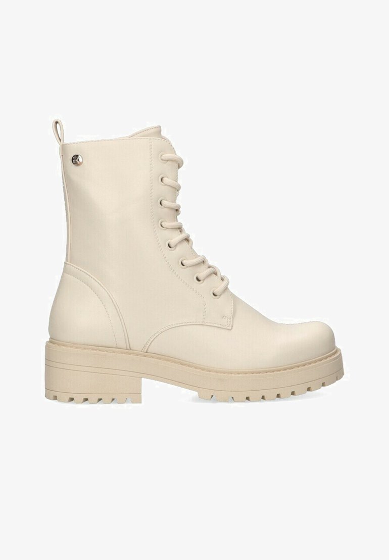 Botas de tobillo beige con cordones, acabado mate, punta redondeada, suela gruesa y un sutil acento metálico en el tacón. Superficie texturizada.