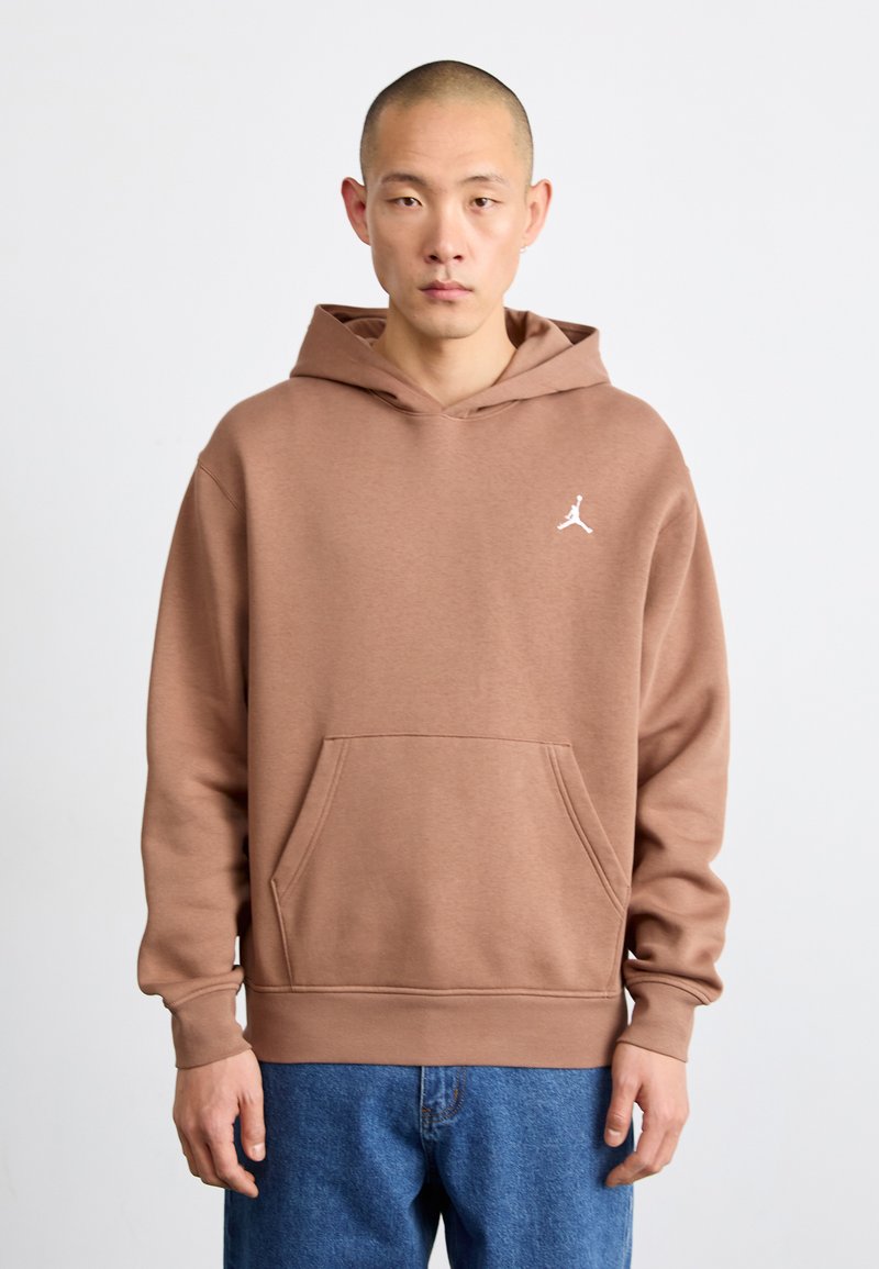 Sweatshirt à capuche marron en tissu doux. Comprend une poche avant et un petit logo Jumpman blanc sur la poitrine. Design à coupe ample.