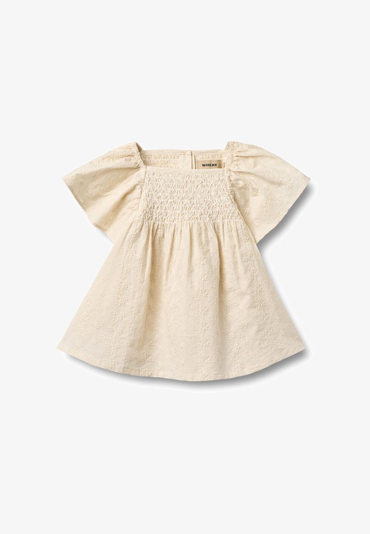 Robe de bébé couleur crème avec manches courtes bouffantes, poitrine froncée et broderie florale subtile sur tout le tissu.