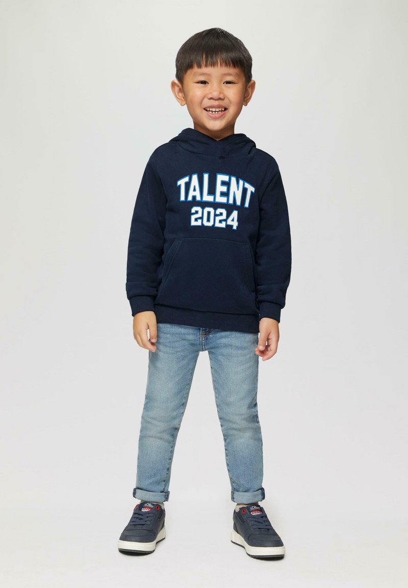 Marineblauwe hoodie met "TALENT 2024" in witte en lichtblauwe tekst, gecombineerd met lichtblauwe jeans en donkere sneakers. Soepele stof, casual pasvorm.