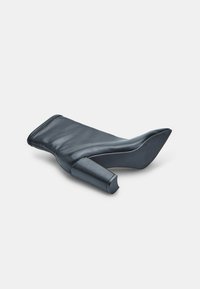 Bota de tacón alto de cuero negro con punta afilada, diseño elegante y tacón de bloque. Se destacan las costuras y la textura suave.