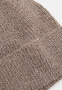 Brown knitted wool beanie featuring a ribbed texture with a folded cuff for added insulation. Soft, warm material with a slightly fuzzy surface.