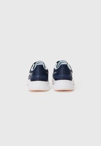 Baskets de sport bleu marine avec une tige en maille texturée, des accents bleu clair contrastants, et une semelle blanche avec une semelle extérieure de couleur pêche.