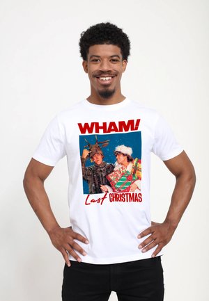 Vit bomull t-shirt med ett grafiskt tryck av två figurer med semester-tema, texten "WHAM! Last Christmas," och färgglada accenter.