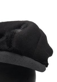 Mustapari hattu, jossa on pehmeä, teksturoitu kangas, pyöreä yläosa ja tasainen, sileä lippa. Sisäpuolella näkyy kerroksittain ommeltuja yksityiskohtia.