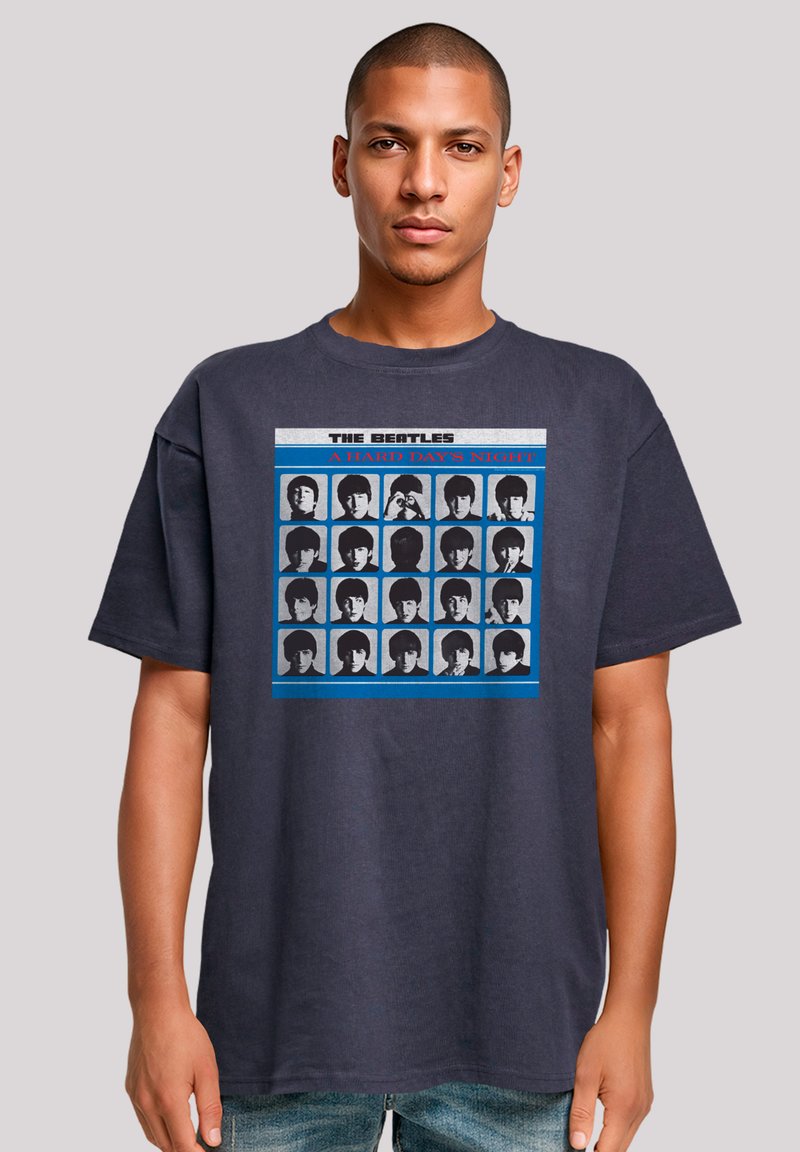Navy blue cotton t-shirt featuring a graphic print of The Beatles with black and white images, framed by blue and gray accents, crew neckline.