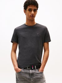 Dark gray short-sleeve t-shirt with a round neckline, featuring a small logo on the chest. Paired with light gray jeans and a black belt with red and blue accents.