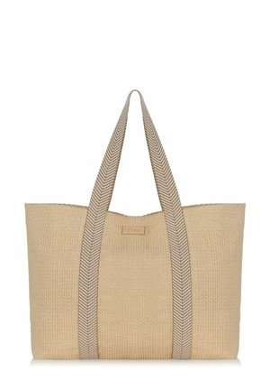 Grote beige geweven tas met brede handvatten in chevronpatroon die van onder naar boven over de tas lopen.