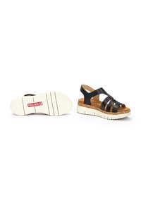 Sandalias de cuero negro con múltiples correas, planta de corcho y una suela blanca de plataforma. Diseño ligero con una correa en el tobillo trasero para mayor soporte.